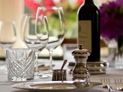a table with glasses and a bottle of wine at Cavens Country House, DINNER INCLUSIVE! in Kirkbean