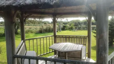 a gazebo with a table and chairs on a porch at Rhins of Galloway in Cairnryan