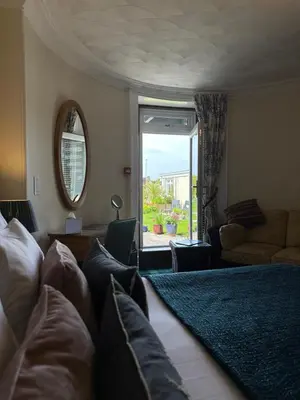 a living room with a bed and a large window at Beaches in Ayr