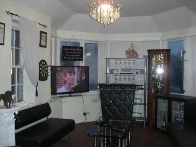 a living room with a tv and a couch and a stove at Lynebank House Hotel, Bed & Breakfast in Carlisle