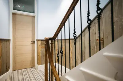 a staircase in a house with a wooden railing at Sail Lofts in Douglas