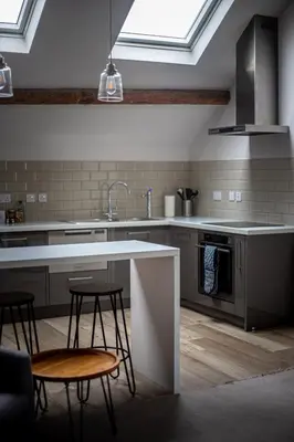 a kitchen with a sink and two chairs and a counter at Sail Lofts in Douglas