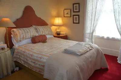 a bedroom with a bed and a window and a lamp at Scaurbridge House in Thornhill