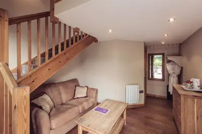 a living room with a couch and a staircase at Tweedies Bar and Lodge in Grasmere
