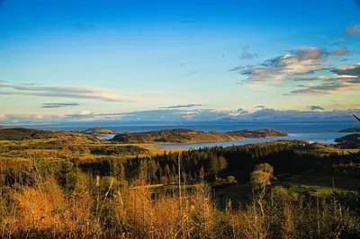 a view of a lake in the middle of a field at Powillimount Cottage in Kirkbean