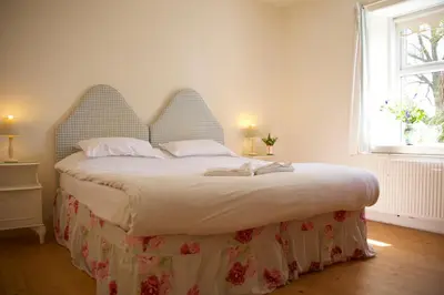 a bedroom with a large bed with a large headboard at West Lodge in Kirkbean