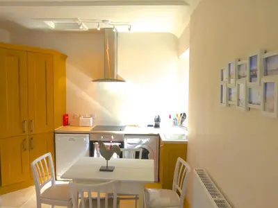 a kitchen with a table and chairs and a stove at Little Dunbar Cottage in Kirkbean