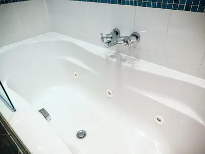 a white bath tub with a faucet in a bathroom at Glen Mona in Douglas