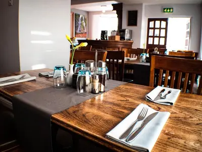 a wooden table in a restaurant with a wooden table sidx sidx at Glen Mona in Douglas