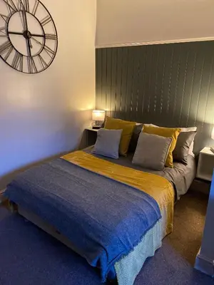 a bedroom with a large bed with a large clock on the wall at Hall Park Hotel self check in in Workington