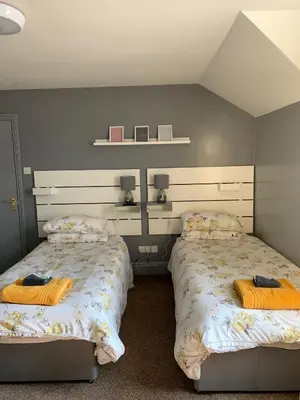 two beds sitting next to each other in a bedroom at Hall Park Hotel self check in in Workington