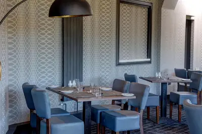 a dining room with tables and blue chairs at Sure Hotel by Best Western Lockerbie in Lockerbie