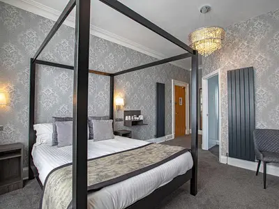 a bedroom with a four poster bed with a chandelier at Sure Hotel by Best Western Lockerbie in Lockerbie