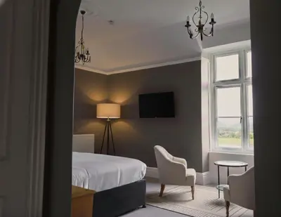 a bedroom with a bed and a table and chairs at Lyzzick in Keswick