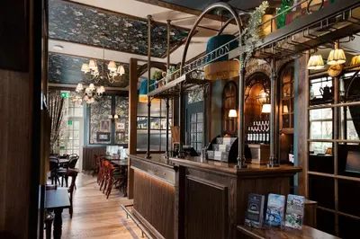 a bar in a restaurant with tables and chairs at The Ullswater Inn- The Inn Collection Group in Glenridding