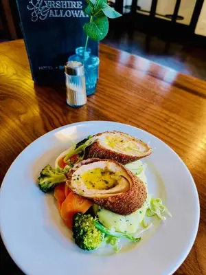 a plate of food with eggs and vegetables on a table at The Ayrshire and Galloway in Ayr