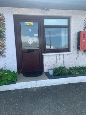 a wooden door on a building with a window at The Thistle in Stranraer