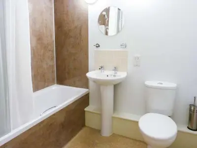 a bathroom with a sink and a toilet and a shower at The Clamshell in Isle of Whithorn