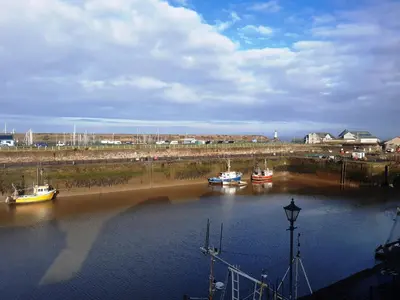 three boats are docked in a body of water at Harbour Side in Maryport