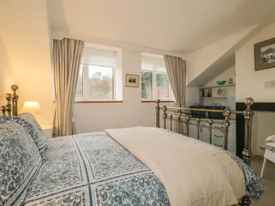 a bedroom with a bed and two windows at Derwent Edge in Portinscale