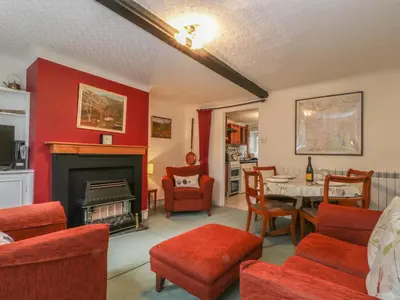 a living room with a fireplace and a table and chairs at Derwent Edge in Portinscale