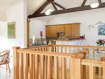 a kitchen with wooden cabinets and a wooden staircase at Skiddaw in Cockermouth