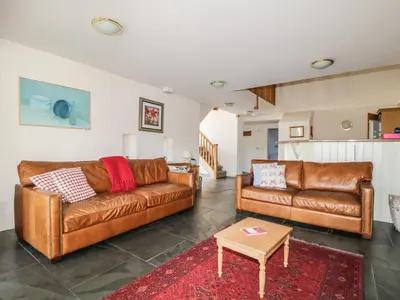 a living room with two brown leather couches and a table at Beckside in Cockermouth