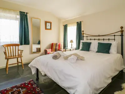 a bedroom with a large white bed and a chair at Buttermere in Cockermouth