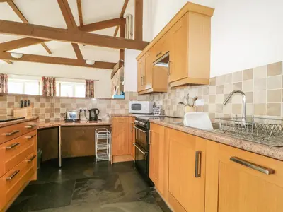 a large kitchen with wooden cabinets and a sink at Buttermere in Cockermouth