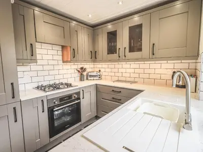 a kitchen with a sink and a stove at Tanner Croft Cottage in Ambleside
