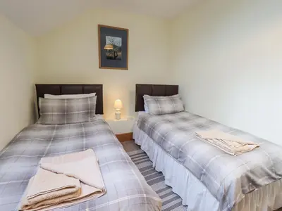 two beds sitting next to each other in a room at Tithe Cottage in Cockermouth