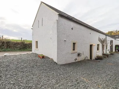a white building sitting on top of a pile of gravel at The Byre in Cockermouth