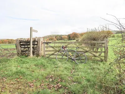 a bike parked next to a fence in a field at The Byre in Cockermouth