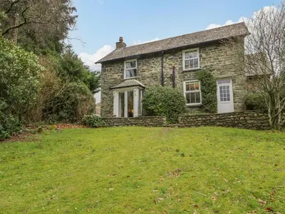 an old stone house with a large yard at The Old Vicarage in Thirlmere