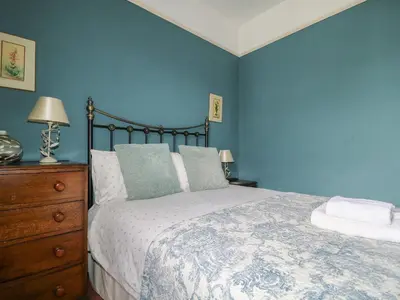 a blue bedroom with a bed and a dresser at Dale House in Cockermouth