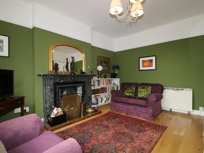 a living room with two purple chairs and a fireplace at Dale House in Cockermouth