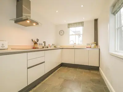 a kitchen with white cabinets and a sink at Roselea in Keswick