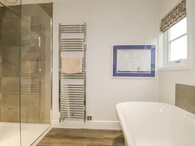 a bathroom with a tub and a glass shower at Roselea in Keswick