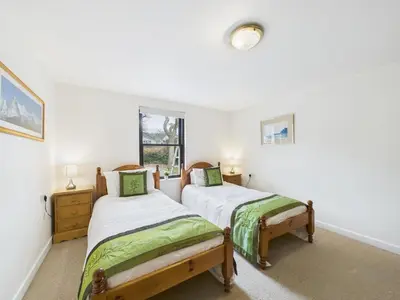 two twin beds in a room with a window at Aura in Keswick