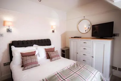 a bedroom with a bed with a flat screen tv at Ravenstone Manor in Keswick