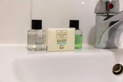three bottles of cosmetics sitting on top of a sink at Elliot Suite No2 - Donnini Apartments in Ayr