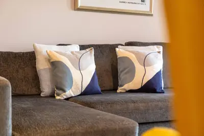 a brown couch with two pillows on it at Elliot Suite No2 - Donnini Apartments in Ayr