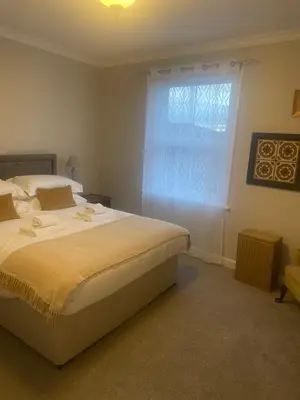 a bedroom with a large bed and a window at The Garret Hotel in Kirkcudbright