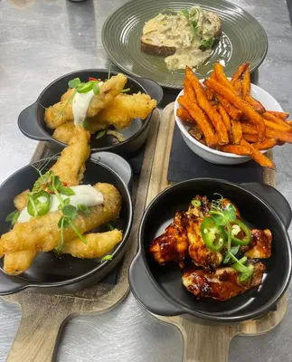 a table with four plates of food and fries at The Garret Hotel in Kirkcudbright