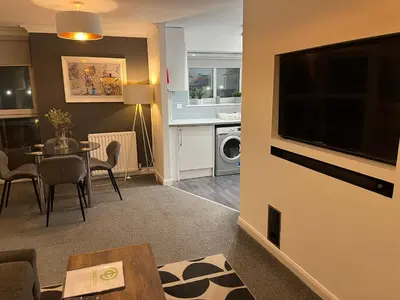 a living room with a television and a dining room at No27 Ayr Beach - Coorie Doon Stays in Ayr