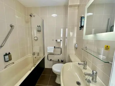a bathroom with a sink and a toilet and a mirror at Carlisle Station Hotel, Sure Hotel Collection by BW in Carlisle