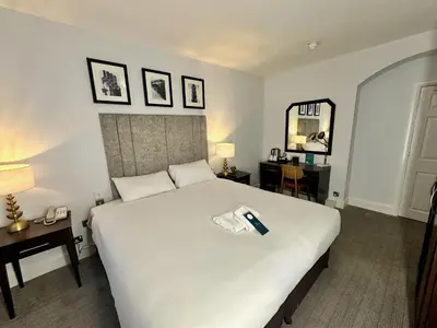 a bedroom with a large white bed with a phone on it at Carlisle Station Hotel, Sure Hotel Collection by BW in Carlisle
