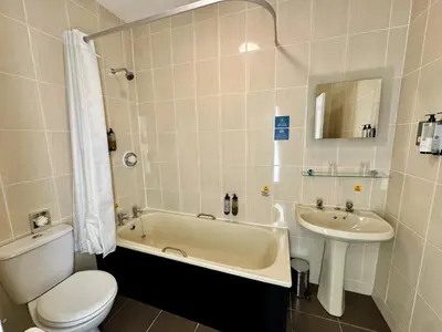 a bathroom with a toilet and a tub and a sink at Carlisle Station Hotel, Sure Hotel Collection by BW in Carlisle