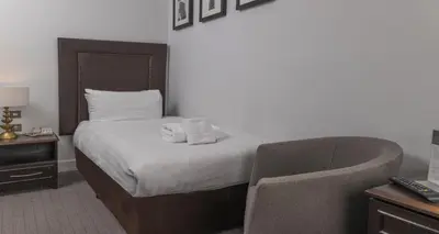 a hotel room with a bed and a chair at Carlisle Station Hotel, Sure Hotel Collection by BW in Carlisle