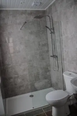 a bathroom with a shower with a toilet and a sink at Keld Green House in Seascale